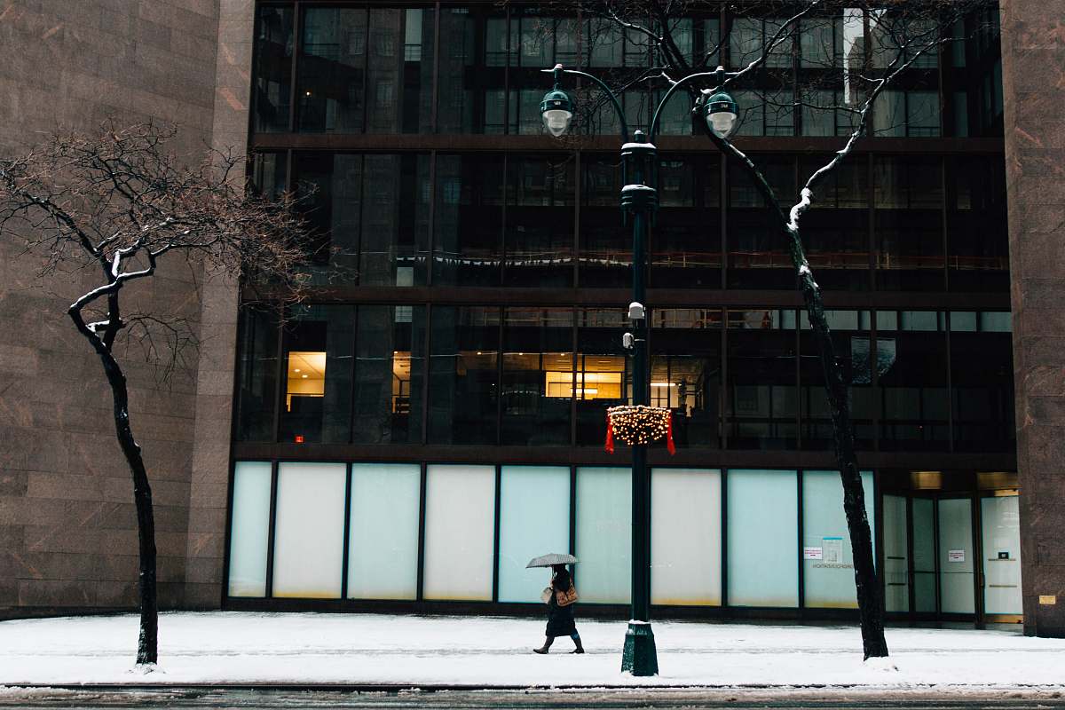 new york person walking beside building while holding umbrella street